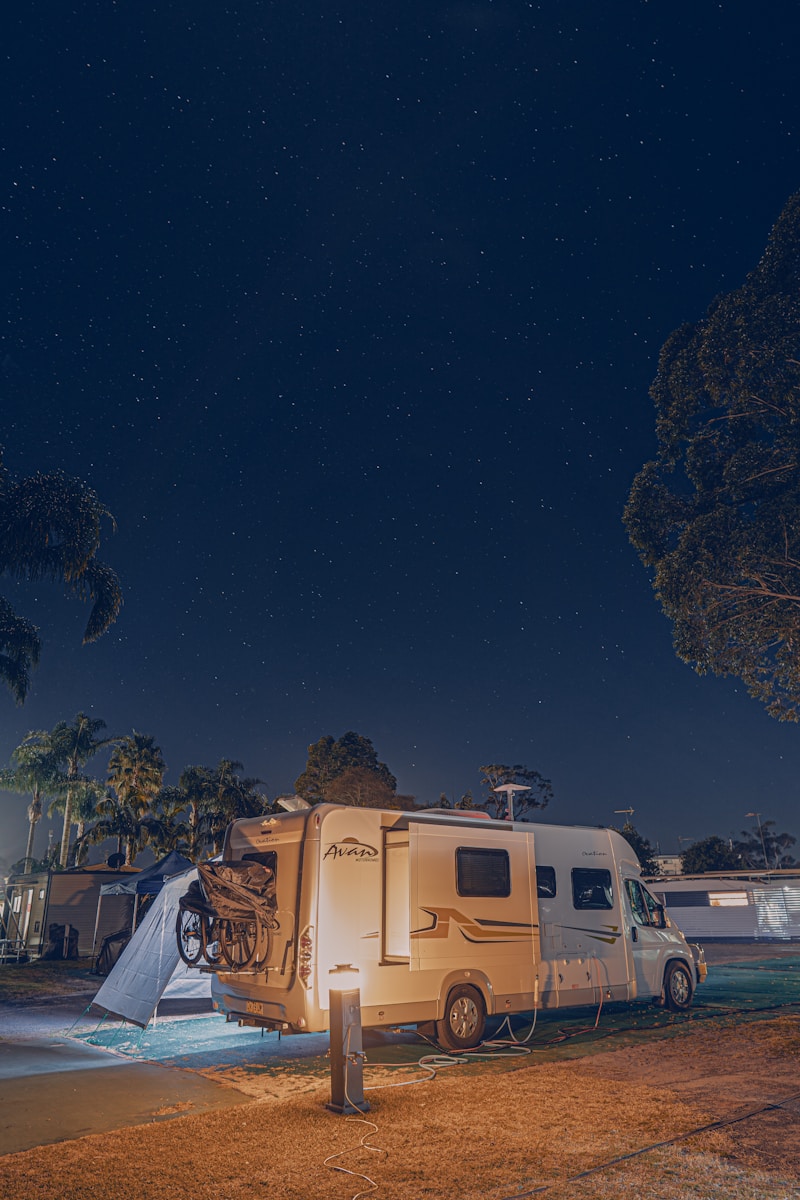 a camper with rv insurance coverage parked next to a tree at night